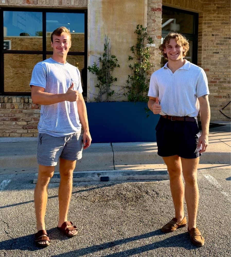 Michael Austinson and Josh Vreeland standing in the parking lot at the Austin field site, with the monitored curb behind them.
